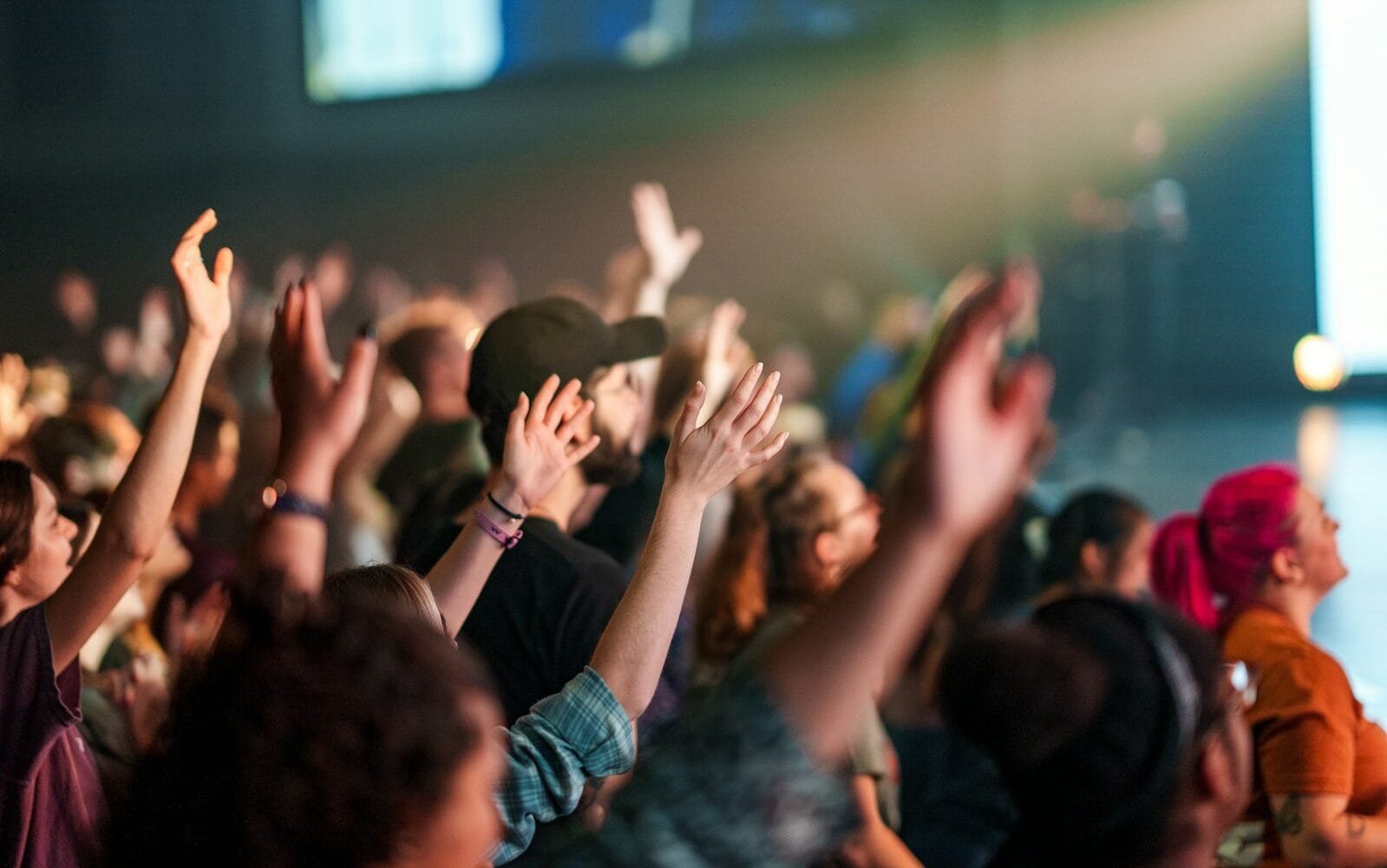 a crowd of people with their hands in the air